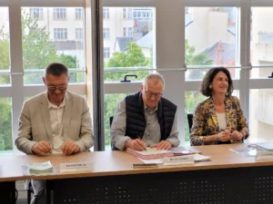 charte-de-mixite_signature1 3 personnes assises à un bureau